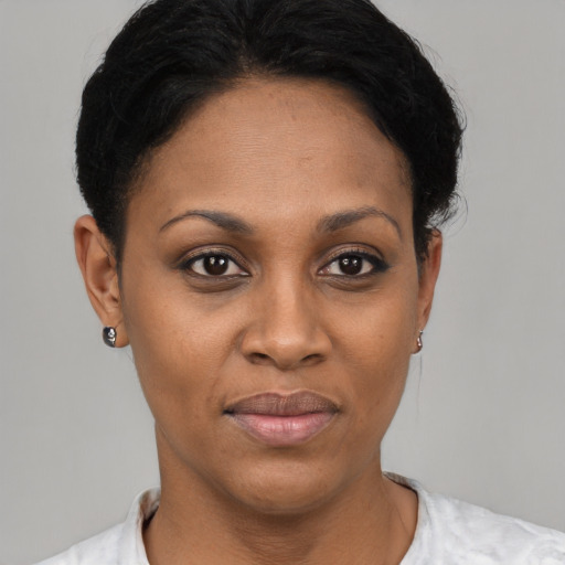 Joyful black young-adult female with short  black hair and brown eyes