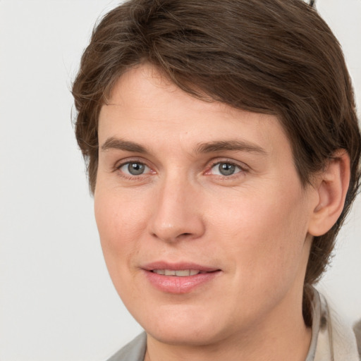 Joyful white young-adult female with medium  brown hair and grey eyes