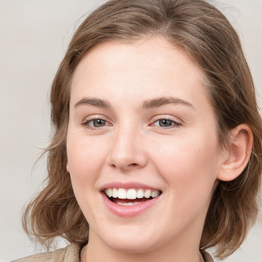 Joyful white young-adult female with medium  brown hair and blue eyes