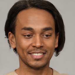 Joyful latino young-adult male with short  brown hair and brown eyes