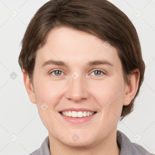 Joyful white young-adult female with short  brown hair and grey eyes