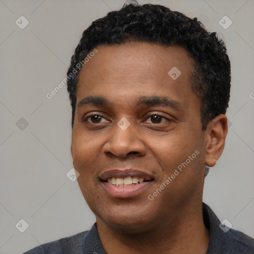 Joyful black young-adult male with short  black hair and brown eyes