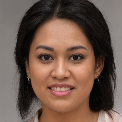 Joyful latino young-adult female with long  brown hair and brown eyes