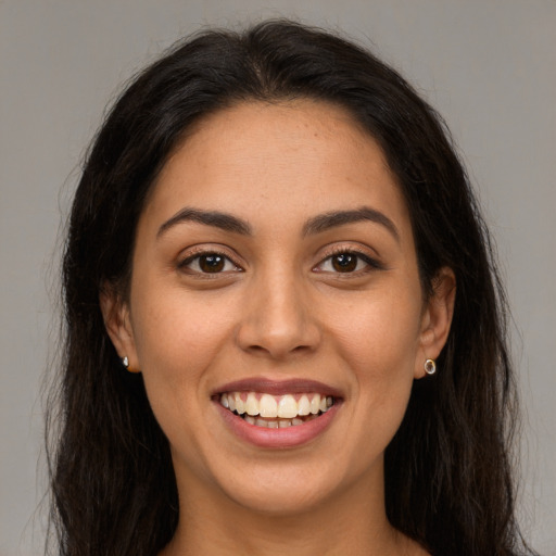 Joyful latino young-adult female with long  brown hair and brown eyes