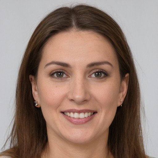 Joyful white young-adult female with long  brown hair and brown eyes