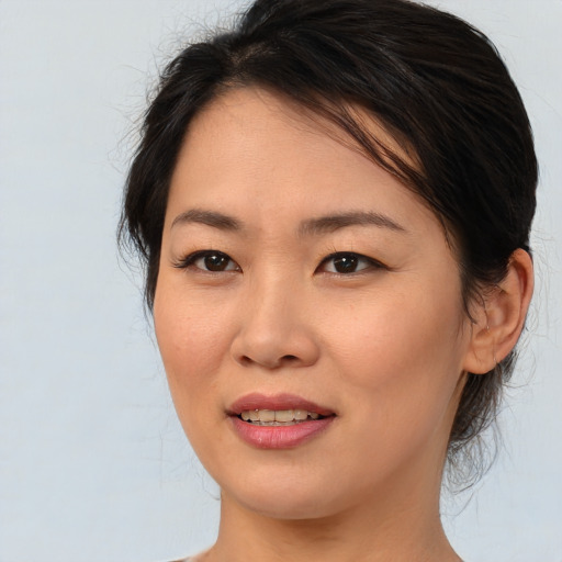 Joyful asian young-adult female with medium  brown hair and brown eyes