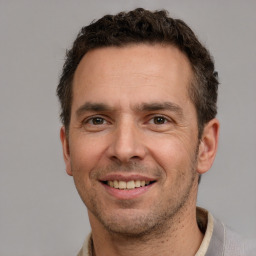 Joyful white adult male with short  brown hair and brown eyes