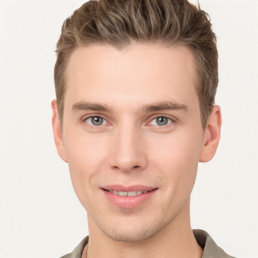 Joyful white young-adult male with short  brown hair and grey eyes