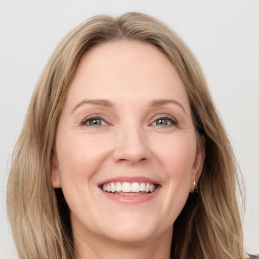 Joyful white adult female with long  brown hair and blue eyes