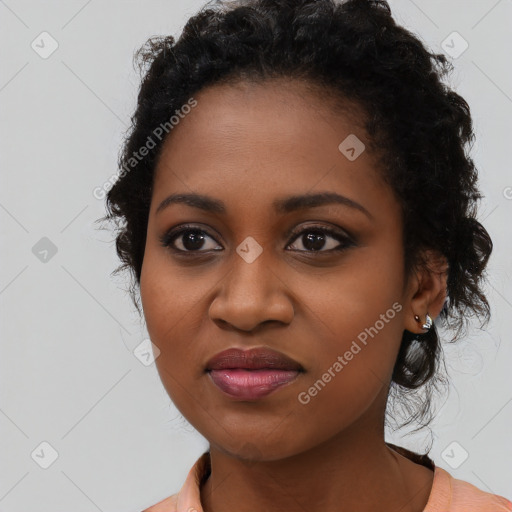 Joyful black young-adult female with long  black hair and brown eyes