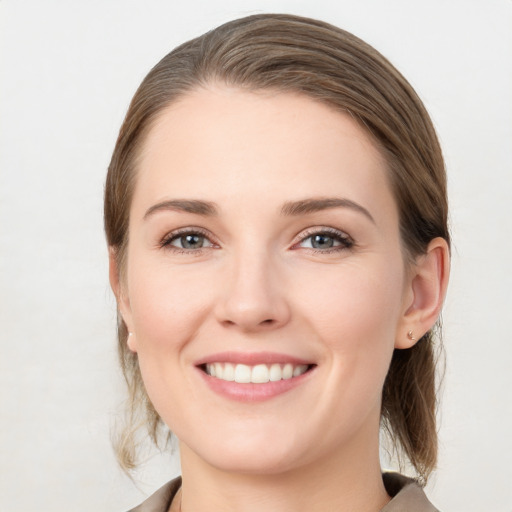 Joyful white young-adult female with medium  brown hair and grey eyes