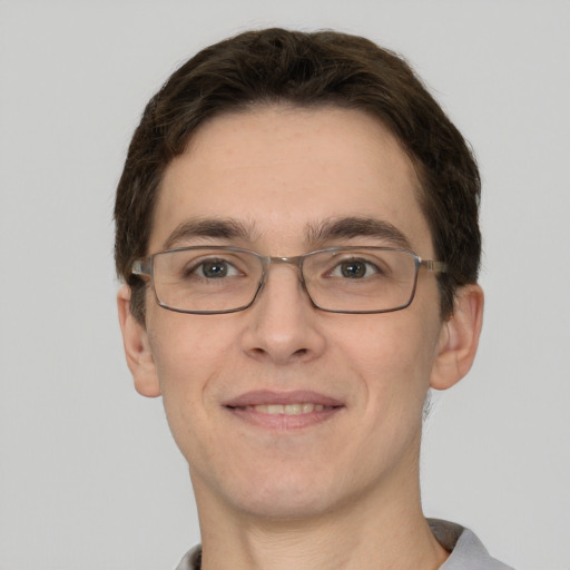 Joyful white young-adult male with short  brown hair and grey eyes