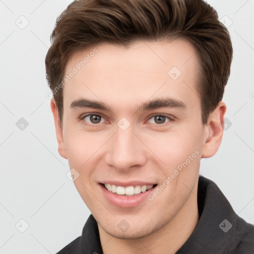 Joyful white young-adult male with short  brown hair and grey eyes