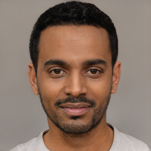 Joyful black young-adult male with short  black hair and brown eyes