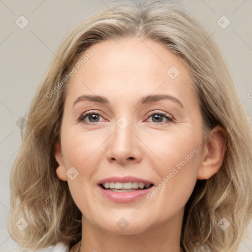 Joyful white adult female with medium  brown hair and grey eyes