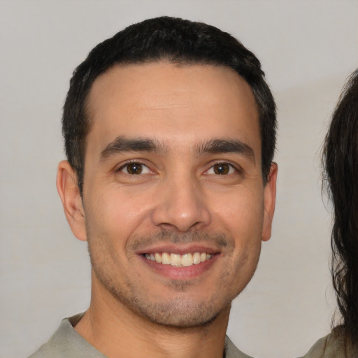 Joyful white young-adult male with short  black hair and brown eyes