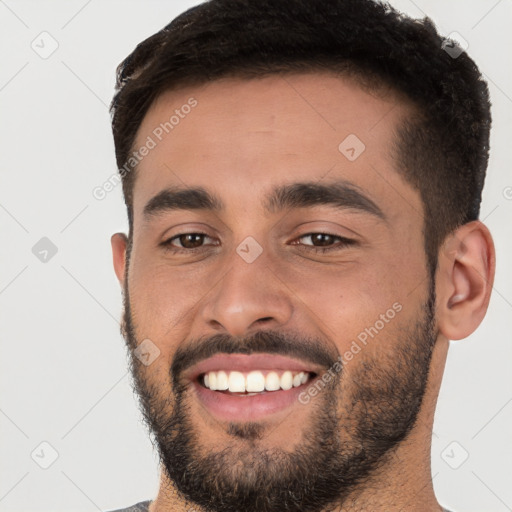 Joyful white young-adult male with short  black hair and brown eyes