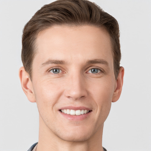 Joyful white young-adult male with short  brown hair and grey eyes