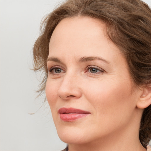 Joyful white young-adult female with medium  brown hair and blue eyes