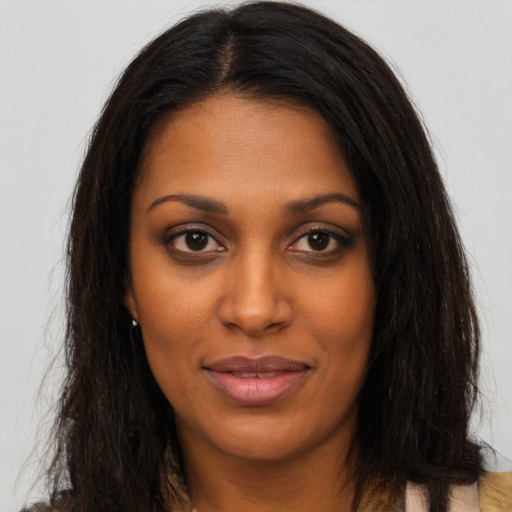 Joyful black young-adult female with long  brown hair and brown eyes