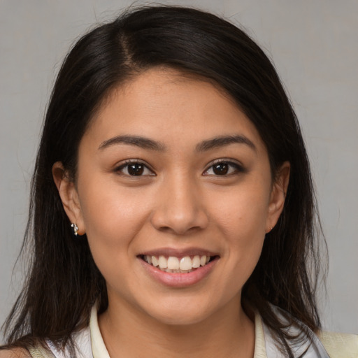 Joyful latino young-adult female with medium  brown hair and brown eyes