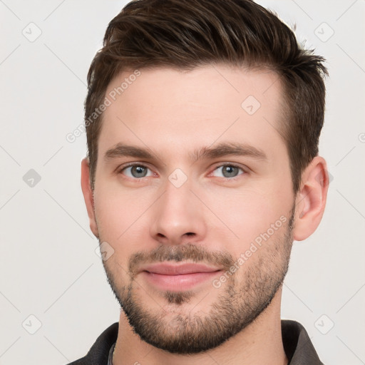 Joyful white young-adult male with short  brown hair and grey eyes