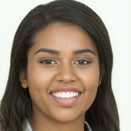 Joyful black young-adult female with long  brown hair and brown eyes