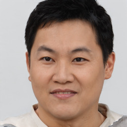 Joyful asian adult male with short  brown hair and brown eyes