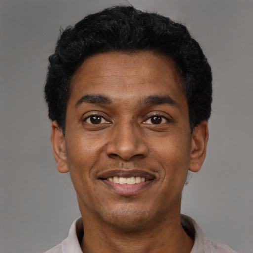Joyful black adult male with short  black hair and brown eyes