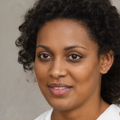 Joyful black young-adult female with medium  black hair and brown eyes