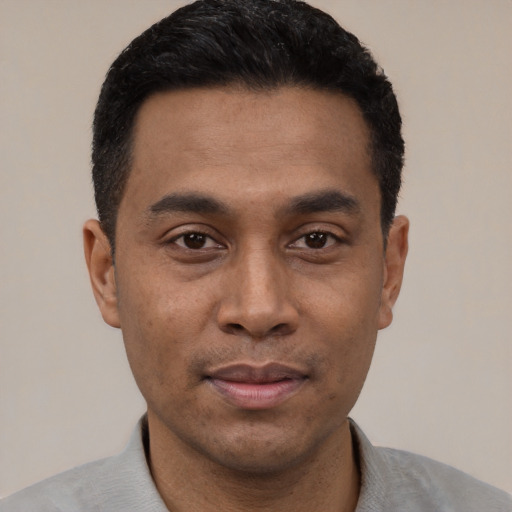 Joyful latino young-adult male with short  black hair and brown eyes