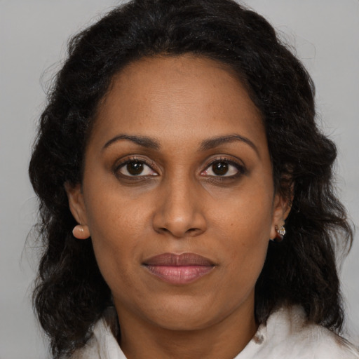 Joyful black adult female with medium  brown hair and brown eyes