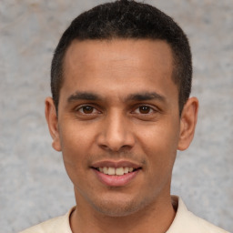 Joyful latino young-adult male with short  black hair and brown eyes