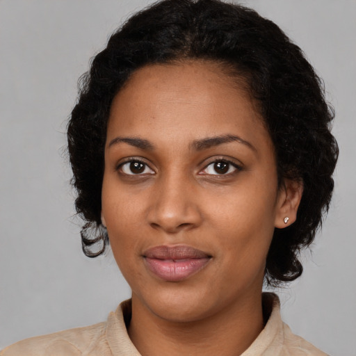 Joyful black young-adult female with medium  black hair and brown eyes