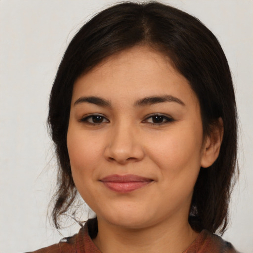 Joyful latino young-adult female with medium  brown hair and brown eyes