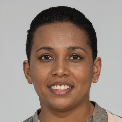 Joyful black young-adult female with short  black hair and brown eyes