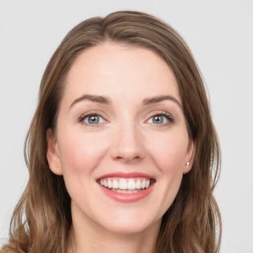 Joyful white young-adult female with long  brown hair and green eyes