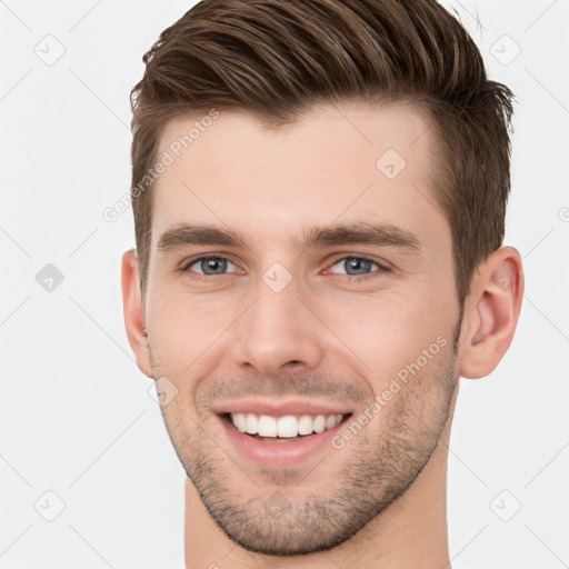 Joyful white young-adult male with short  brown hair and grey eyes