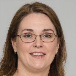 Joyful white adult female with medium  brown hair and blue eyes