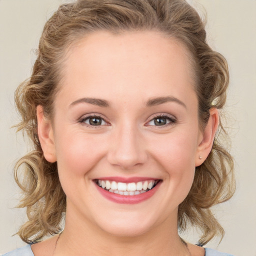 Joyful white young-adult female with medium  brown hair and blue eyes