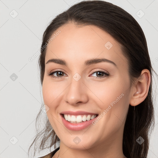 Joyful white young-adult female with long  brown hair and brown eyes