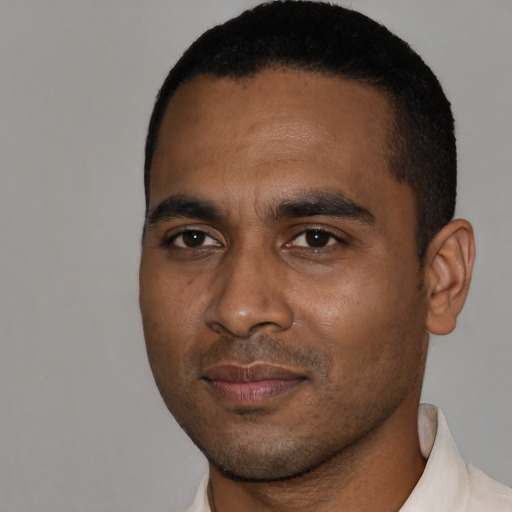 Joyful black young-adult male with short  black hair and brown eyes