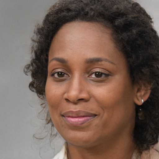 Joyful black adult female with long  brown hair and brown eyes