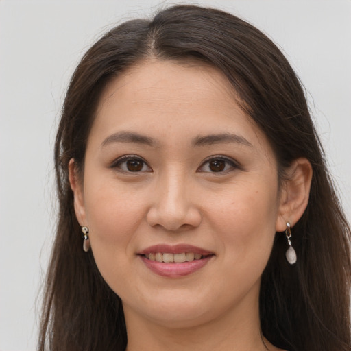 Joyful white young-adult female with long  brown hair and brown eyes