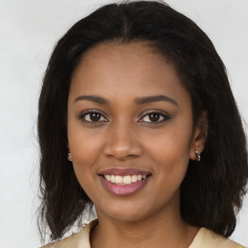 Joyful black young-adult female with long  brown hair and brown eyes