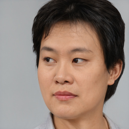 Joyful asian young-adult male with medium  black hair and brown eyes