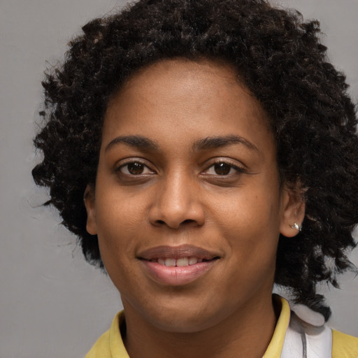 Joyful black young-adult female with medium  brown hair and brown eyes