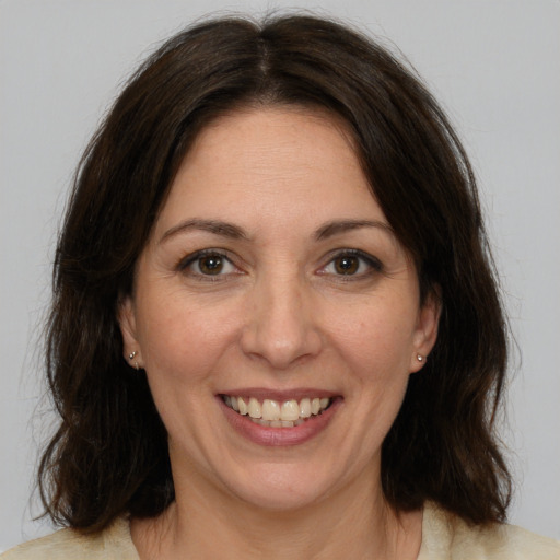 Joyful white adult female with medium  brown hair and brown eyes