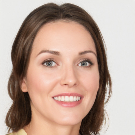 Joyful white young-adult female with medium  brown hair and green eyes