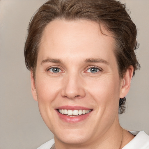 Joyful white young-adult female with short  brown hair and grey eyes